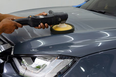 男人。持有工具波兰的机械师汽车修复详细说明罩车刮伤维护车库洗车工作