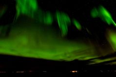 美丽的绿色极光北欧化工北部灯的天空特罗姆瑟挪威