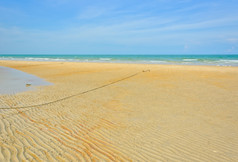 海滩沙子涟漪模式对蓝色的天空