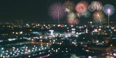 色彩斑斓的烟花模糊摩天大楼与城市散景灯照亮晚上摘要新一年假期聚会，派对背景