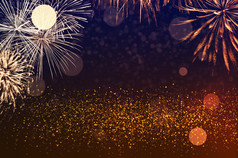 摘要黄金黑色的和橙色闪闪发光的背景与烟花庆祝活动和周年纪念日概念