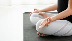 女人练习瑜伽莲花位置padmasana与穆德拉盘腿坐着冥想构成白色卧室后之后的早....概念锻炼放松和医疗保健