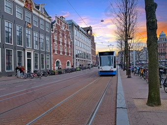 有轨电车开车的城市中心从阿姆斯特丹的荷兰日落有轨电车开车的城市中心从阿姆斯特丹的荷兰