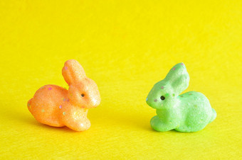 两个色彩斑斓的<strong>小兔子</strong>使用为装饰在的复活节期孤立的黄色的背景