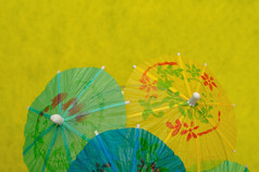 开放鸡尾酒雨伞显示黄色的背景