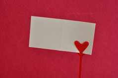 情人节一天请注意持有人与红色的心与空卡孤立的对粉红色的背景