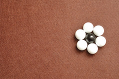 白色和黑色的球包装的形状花孤立的棕色（的）背景