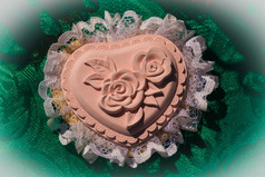 石膏粉红色的心盒子与花边而且高救援玫瑰绿色桌布背景