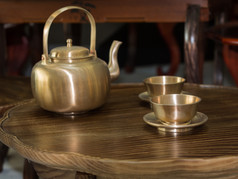 传统的亚洲金茶壶和杯小木表格