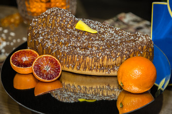 甜蜜的意大利蛋糕典型的的庆祝活动覆盖与巧克力和装饰与橙子周围甜蜜的意大利蛋糕典型的的庆祝活动覆盖与巧克力和装饰与橙子周围