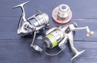 两个银色的钓鱼卷备用卷与钓鱼行和两个轮盒子为小齿轮钓鱼gear-reels和钓鱼行