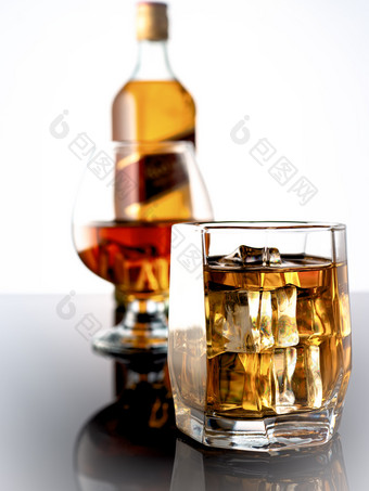 威士忌与冰黑暗背景的背景玻璃威士忌和完整的瓶威士忌玻璃威士忌与冰黑暗背景的背景玻璃与威士忌和瓶威士忌
