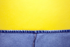 蓝色的牛仔裤与黄色的针而且黄色的背景