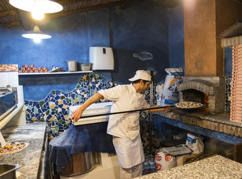 戈尔福阿兰奇4月-老板使披萨原始木质的披萨烤箱戈尔福阿兰奇这的地方著名的萨迪尼的海岸线和的海豚披萨烘焙原始烤箱披萨烘焙原始烤箱