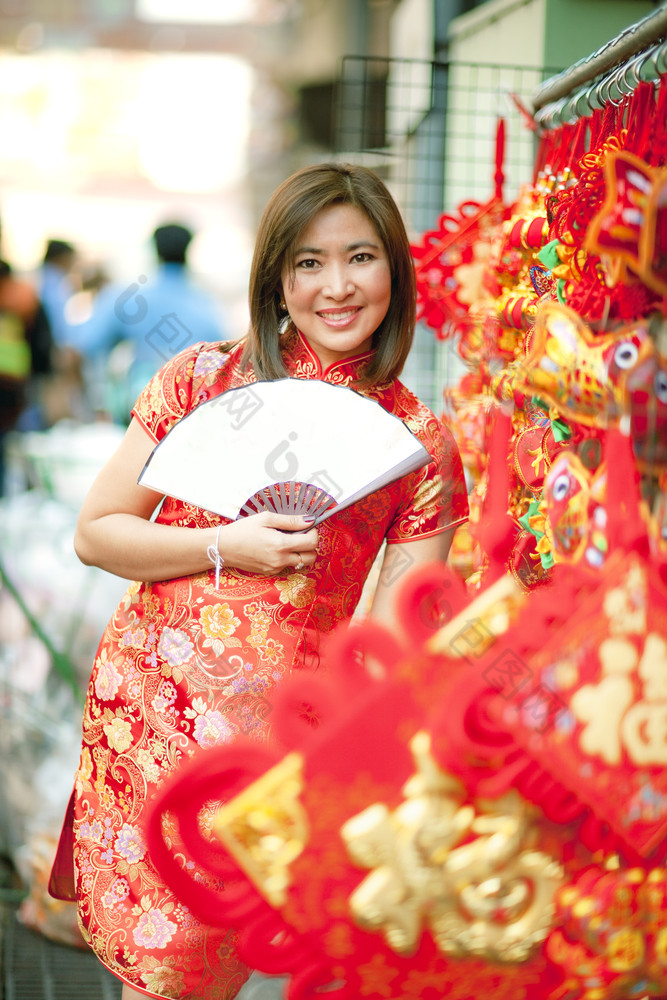 亚洲女人穿中国人传统衣服与中国人竹子风扇微笑脸耀华力街中国小镇曼谷泰国