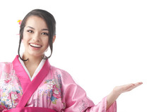 肖像的年轻的日本女人穿传统的和服衣服而且显示某物的白色背景腰