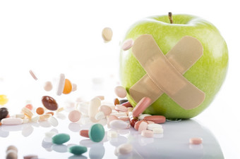 绿色苹果与邦迪牌创可贴而且一些药片绿色苹果与邦迪牌创可贴而且一些药片白色背景