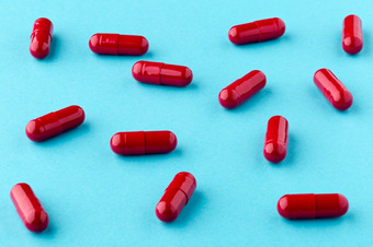 药物红色的胶囊分散的蓝色的背景药用红色的胶囊分散的表格的蓝色的背景