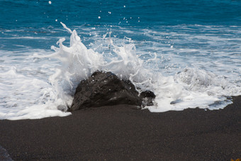 海波崩溃对的石头的海滩与黑色的沙子金丝雀岛海波崩溃对的石头海洋