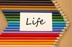 生活文本概念和彩色的铅笔木背景