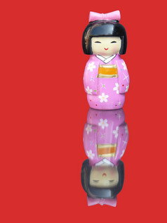 瓷中国人小雕像与镜子图像孤立的红色的背景