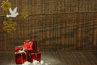 <strong>四个</strong>小装饰雪覆盖圣诞节礼物黄金贴纸雪花和白色鸽子老木圣诞节装饰问候卡与复制空间水平视图