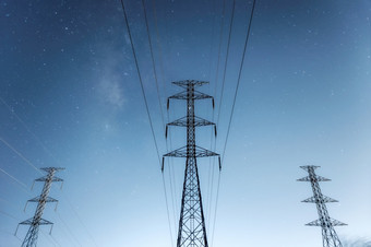 高电压电桥塔和传输权力行和部分电设备和高电压权力行绝缘体晚上与乳白色的道路蓝色的语气高电压电桥塔晚上