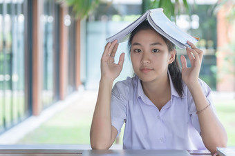 年轻的亚洲大学学生统一的美丽的女孩放松和微笑读书与放松情绪咖啡商店为学习在线休闲业务社会会议教育概念教育概念