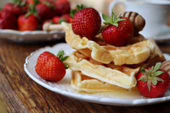比利时华夫饼与新鲜的浆果草莓蜂蜜和卡布奇诺咖啡咖啡为早餐比利时华夫饼与新鲜的浆果草莓蜂蜜和卡布奇诺咖啡咖啡为早餐