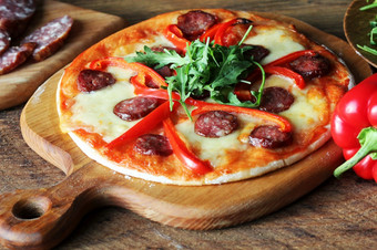 热自制的披萨与意大利辣香肠papricarucola木表格热自制的披萨与意大利辣香肠papricarucola木表格