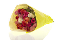 花束色彩斑斓的混合玫瑰包装黄色的纸孤立的在白色背景