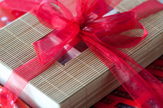 特写镜头红色的弓礼物包装周围盒子使竹子棒