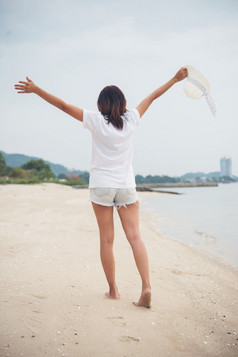 肖像年轻的女人走的海滩光着脚