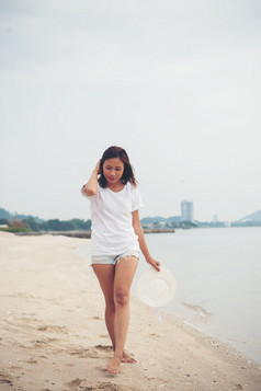 肖像年轻的女人走的海滩光着脚