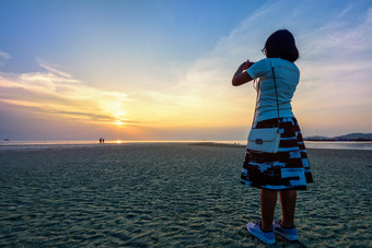 亚洲女人<strong>旅游</strong>采取照片的海滩和美丽的自然景观色彩斑斓的天空和海在日落纳通日落的观点寒岛这封信他尼府<strong>泰国</strong>女人<strong>旅游</strong>采取照片的海滩