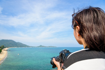 十几岁的女孩持有数码单反相机相机高和美丽的自然景观的蓝色的海Lamai海滩高的观点在夏天旅行KOH寒岛这封信他尼府泰国十几岁的女孩持有相机高