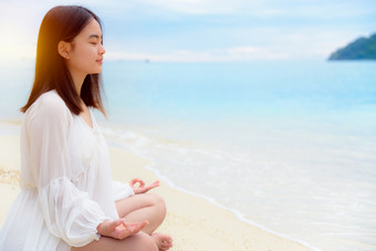美丽的亚洲年轻的女人实践瑜伽的海滩附近的海下阳光日出放松为健康的中间自然与幸福和和平空白为的背景亚洲年轻的女人实践瑜伽的海滩