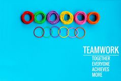 团队合作概念集团色彩斑斓的橡胶乐队蓝色的背景与词团队合作在一起每一个人达到和更多的