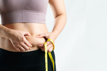 脂肪女人脂肪肚子胖乎乎的肥胖女<strong>人手</strong>持有过度肚子脂肪与测量磁带女人饮食生活方式概念