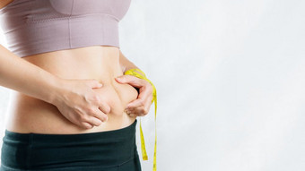脂肪女人脂肪肚子胖乎乎的肥胖女人手持有过度肚子脂肪与测量磁带女人饮食生活方式概念