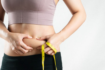 脂肪女人脂肪肚子胖乎乎<strong>的</strong>肥胖女人手持有过度肚子脂肪与测量磁带女人饮食生活方式概念