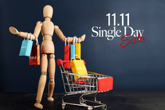 单身一天出售概念购物狂木娃娃与很多购物袋手臂和购物车