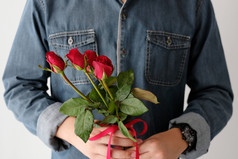 情人节概念男人。持有红色的玫瑰白色背景