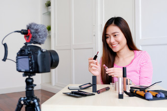 年轻的亚洲女人美博主显示化妆品而记录如何使视频教程相机视频博客概念美和时尚人和技术沟通
