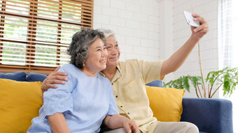 快乐高级亚洲夫妇采取自拍首页生活房间活跃的高级人快乐时刻休闲退休人与技术和生活方式