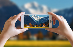 手取照片不错的山和天空风景视图与移动智能手机