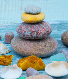 海鹅卵石和贝壳的表格金字塔海石头蓝色的背景金字塔海石头蓝色的背景海鹅卵石和贝壳的表格