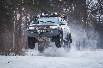 运动型多功能车跳的上升雪冬天森林运动型多功能车跳上升雪冬天森林