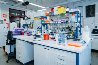 室内现代实验室桌子上与佩特里菜测试管烧瓶和现代显微镜前景全景窗户与百叶窗背景室内现代实验室与研究设备