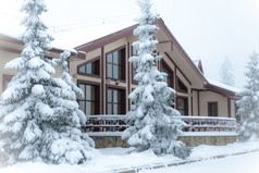 美丽的冬天森林和白雪覆盖的房子冷杉和松树的雪景观